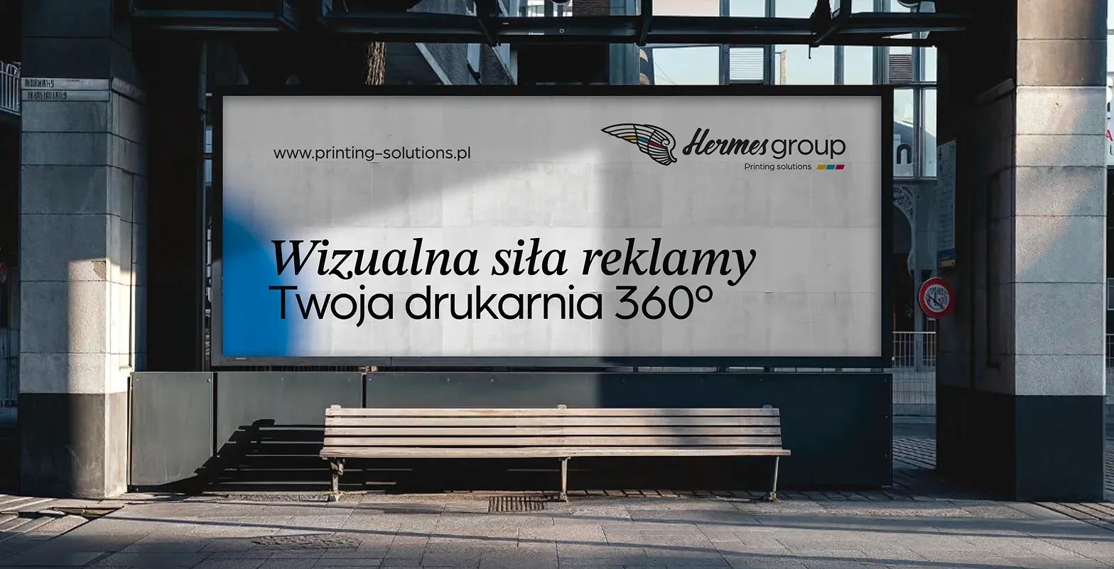 Duży billboard reklamowy Hermes Group z hasłem Wizualna siła reklamy umieszczony nad ławką miejską.
